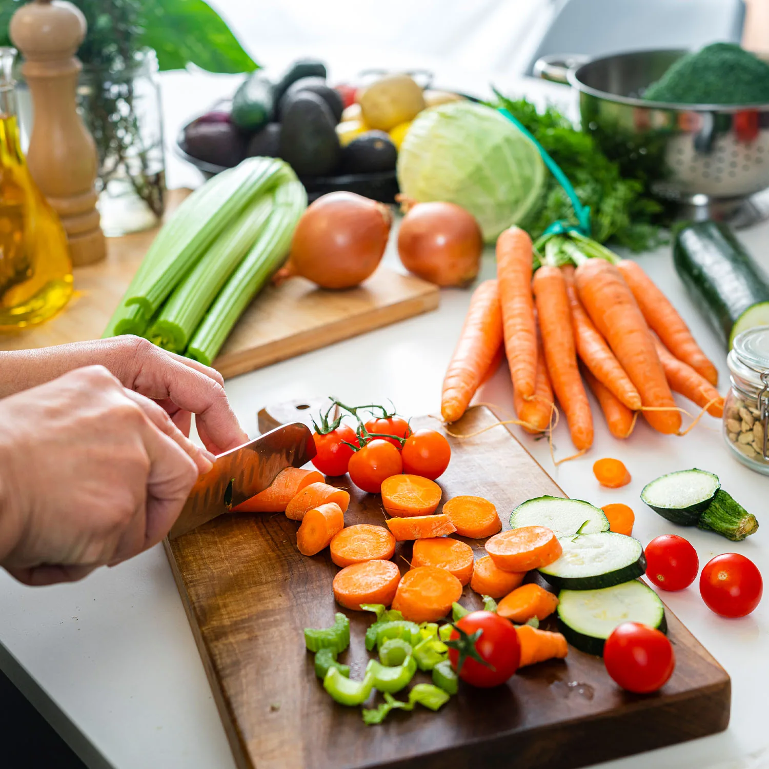 Ein Tisch voller frischer Gemüsesorten die auf einem Holzbrett geschnitten werden.