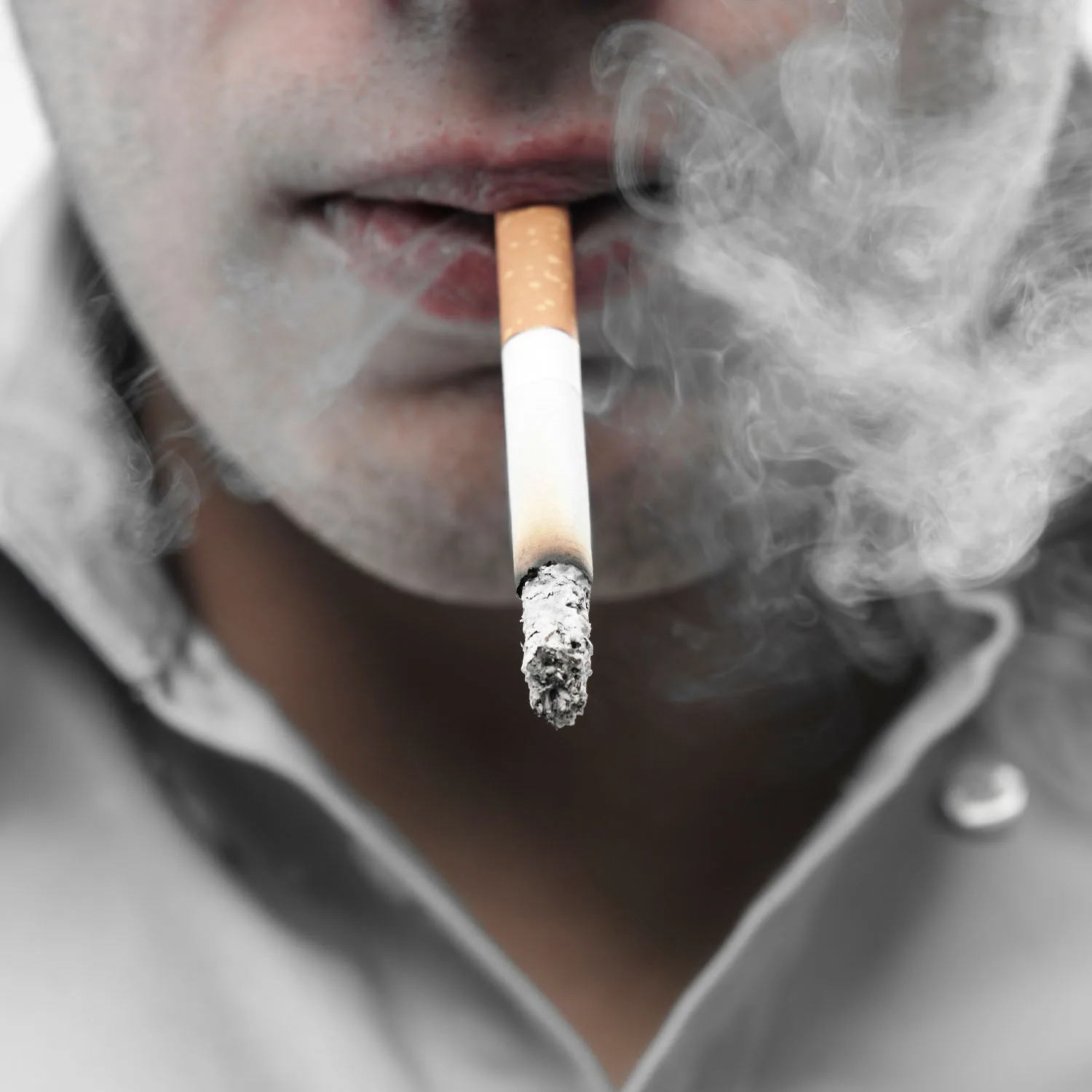 Nahaufnahme einer Zigarette die geraucht wird mit Qualm.